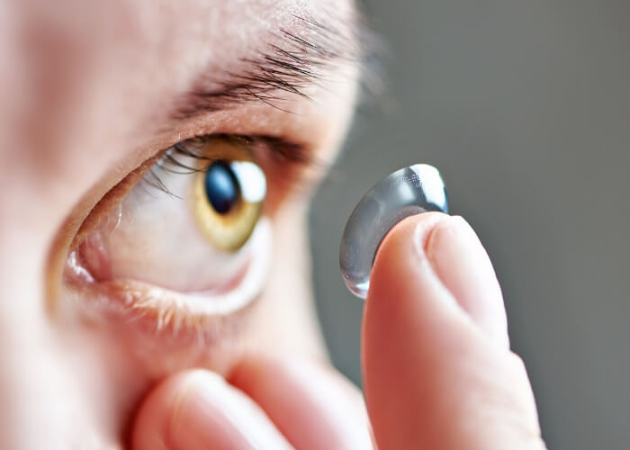  Young man preparing to place a contact lens in his eye 
